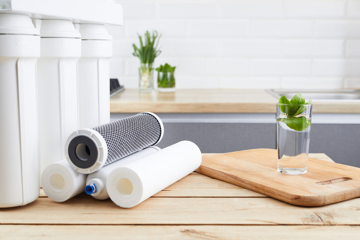 a glass of water on a cutting board in a home with a Reverse Osmosis System in North Barrington