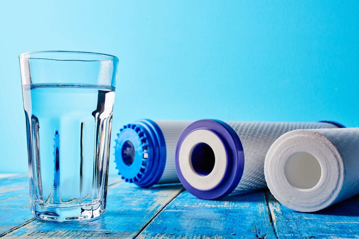glass of water next to filters used for The Benefits of Whole-House Reverse Osmosis System in Port Barrington, IL